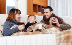 Family Relaxing On Couch With Drinks In Their Hands