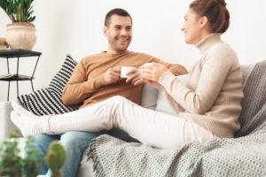 Happy Couple Sipping Coffee On Couch